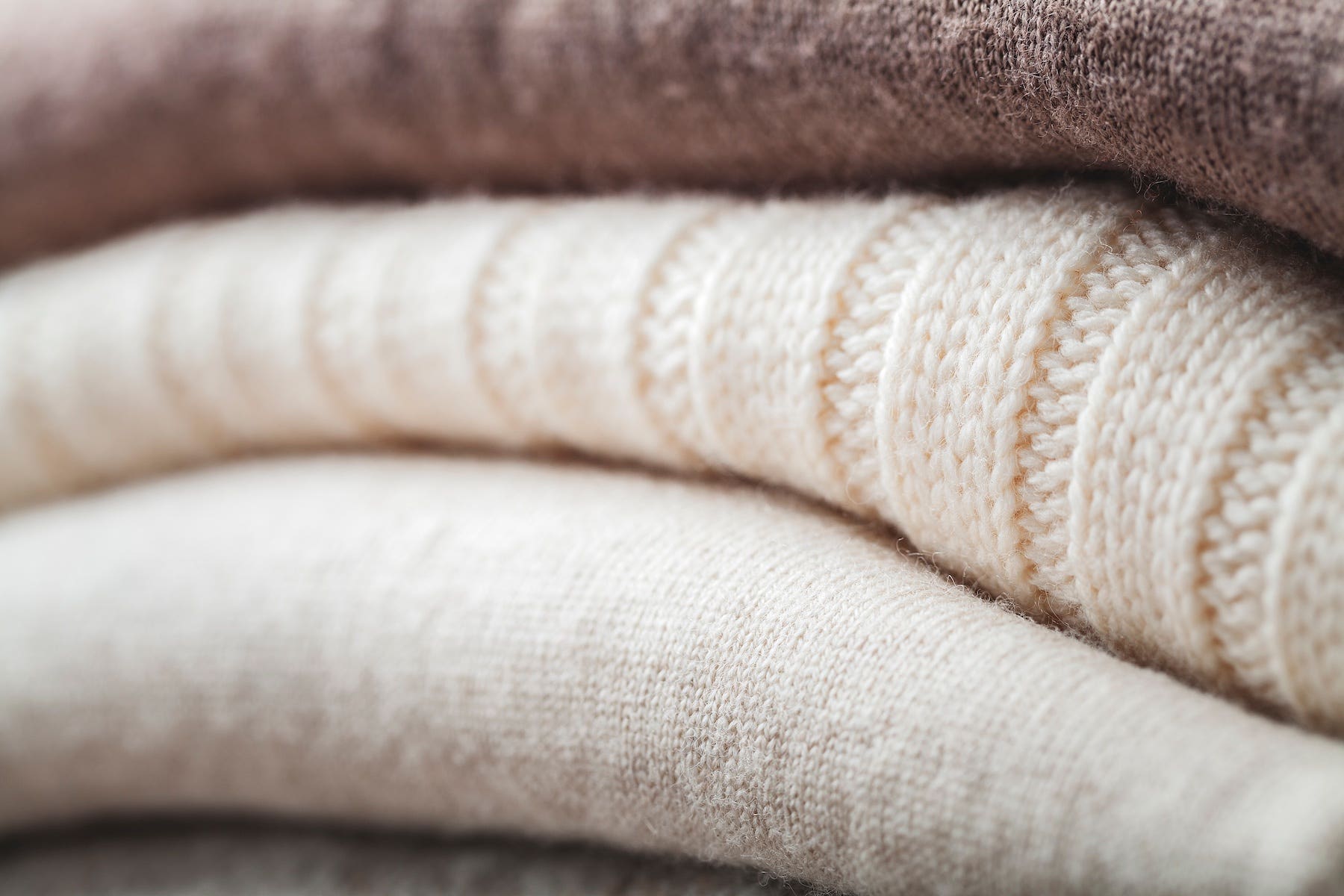 Closeup of warm winter knits in neutral colours at Style Trend Clothiers