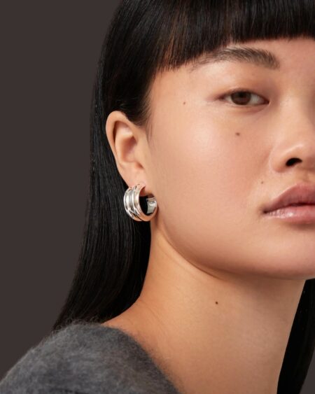 Close up of half a womans face with bold silver hoops in her ear visible